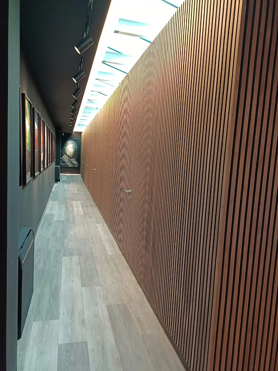 Boiserie a doghe in legno illuminata in corridoio